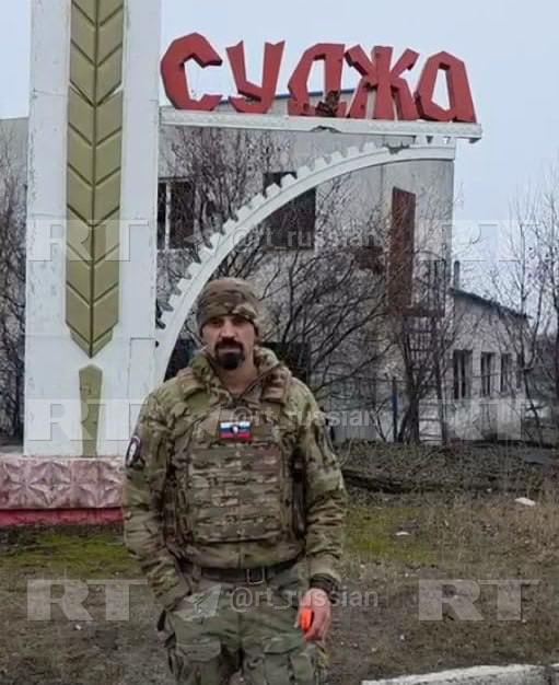 Российский военный с позывным Кузя рядом со стелой на въезде в Суджу